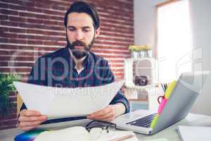 Confident creative businessman examining document