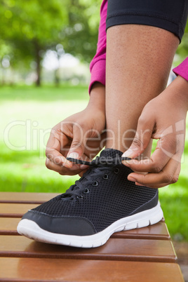 Woman tying her shoelace on running shoe