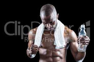 Athlete with towel around neck holding water bottle