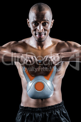 Portrait of muscular man exercising with kettlebell