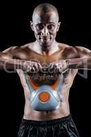 Portrait of muscular man exercising with kettlebell