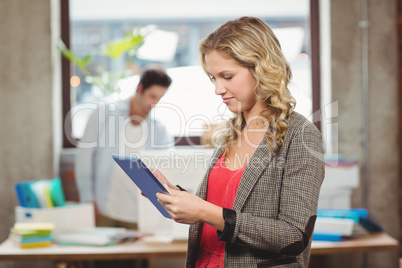 Woman working on digital tablet in office