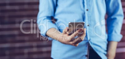 Midsection of man holding cellphone