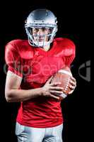 Confident American football player holding ball