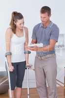 Woman with crutch speaking with his doctor