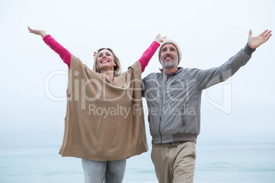 Cute couple standing with arms open wide