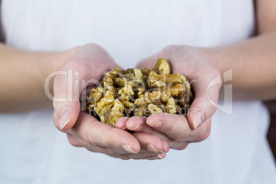 Woman showing handful of walnuts