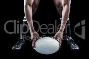 Low section of sportsman holding ball while playing rugby