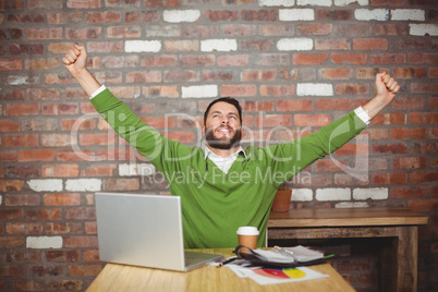 Businessman with arms raised in office Businessman with arms raised in office