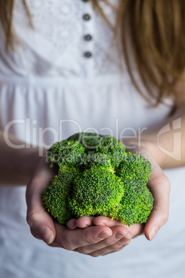 Woman showing fresh green brocolli