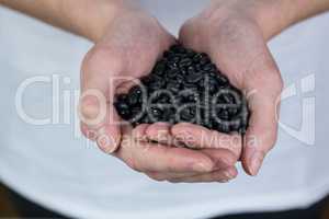 Woman showing handful of black beans