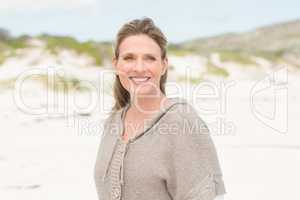 Smiling woman standing on the sand