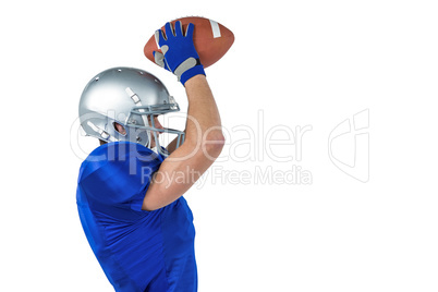 Porfile view ofAmerican football player catching ball