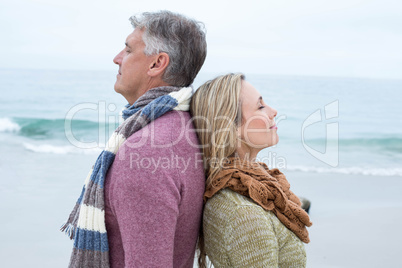 Happy couple standing back to back