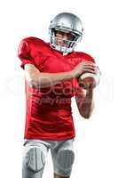 Confident American football player in red jersey holding ball