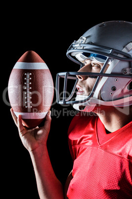 Sportsman looking up while holding American football
