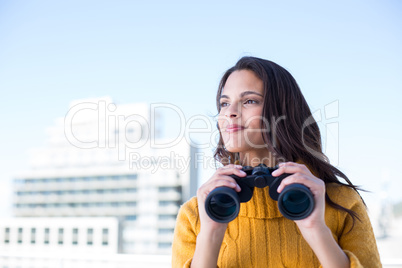 Pretty brunette holding binoculars