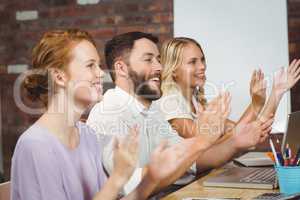 Happy colleagues clapping at meeting