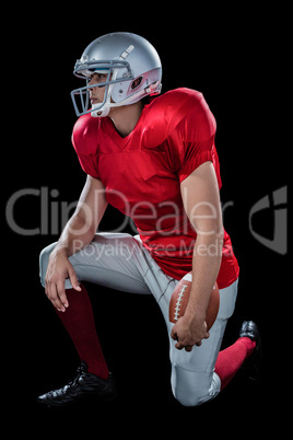 American football player looking away while kneeling