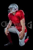 American football player looking away while kneeling