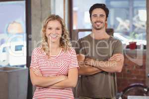 Portrait of man and woman with arms crossed in office