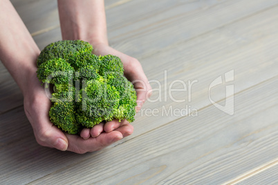 Woman showing fresh green brocolli