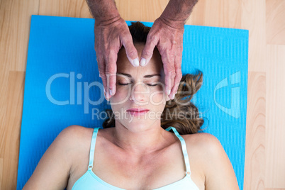 Overhead view of pregnant woman getting reiki treatment