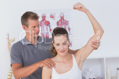 Doctor stretching a young woman arm