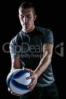 Handsome rugby player holding ball