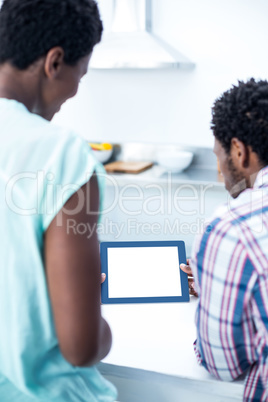 Rear view of couple looking at digital tablet