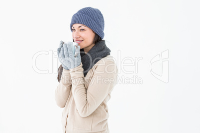 Smiling brunette drinking hot beverage