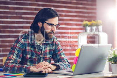 Confident businessman working on laptop