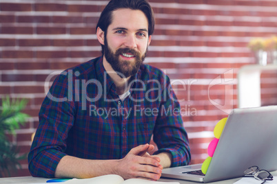 Portrait of smiling creative editor with laptop