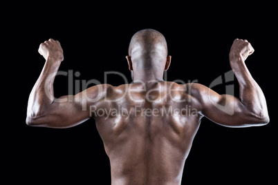 Rear view of muscular athlete posing