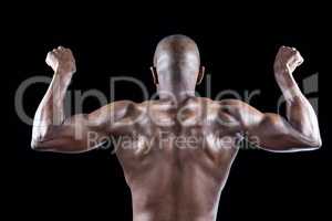 Rear view of muscular athlete posing