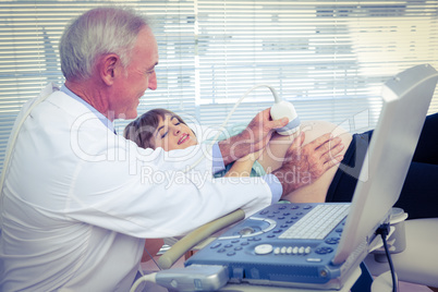 Male doctor doing ultrasound test on pregnant woman