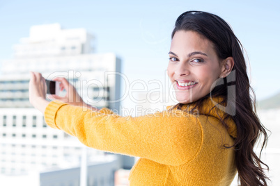 Pretty brunette taking photos with her smartphone