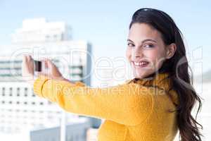 Pretty brunette taking photos with her smartphone