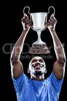 Happy sportsman looking up while holding trophy