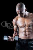 Muscular athlete exercising with dumbbell