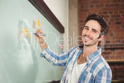 Portrait of smiling businessman holding marker in office