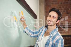 Portrait of smiling businessman holding marker in office