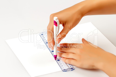girl draws a pen on a ruler on paper