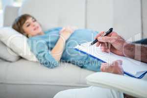 Midsection of gynecologist writing prescription on clipboard