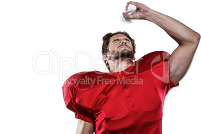 American football player in red jersey pouring water on face