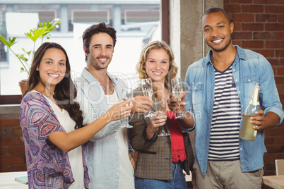 Portrait of business people toasting with champagne in office