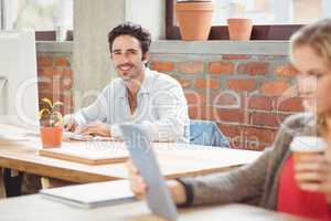 Portrait of smiling businessman working on computer