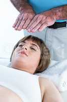 Close-up of calm woman receiving reiki treatment