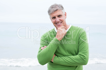 Smiling man standing at the shoreline