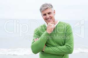 Smiling man standing at the shoreline